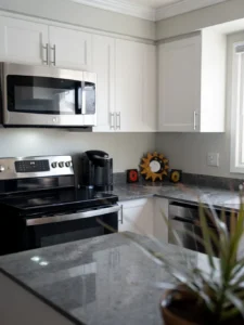Modern kitchen with stainless steel appliances, granite countertop, and decorative wall art.